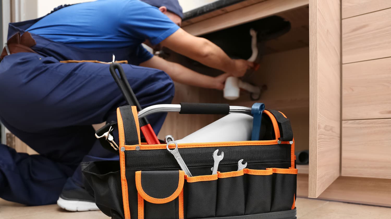 Man doing plumbing works with toolset bag